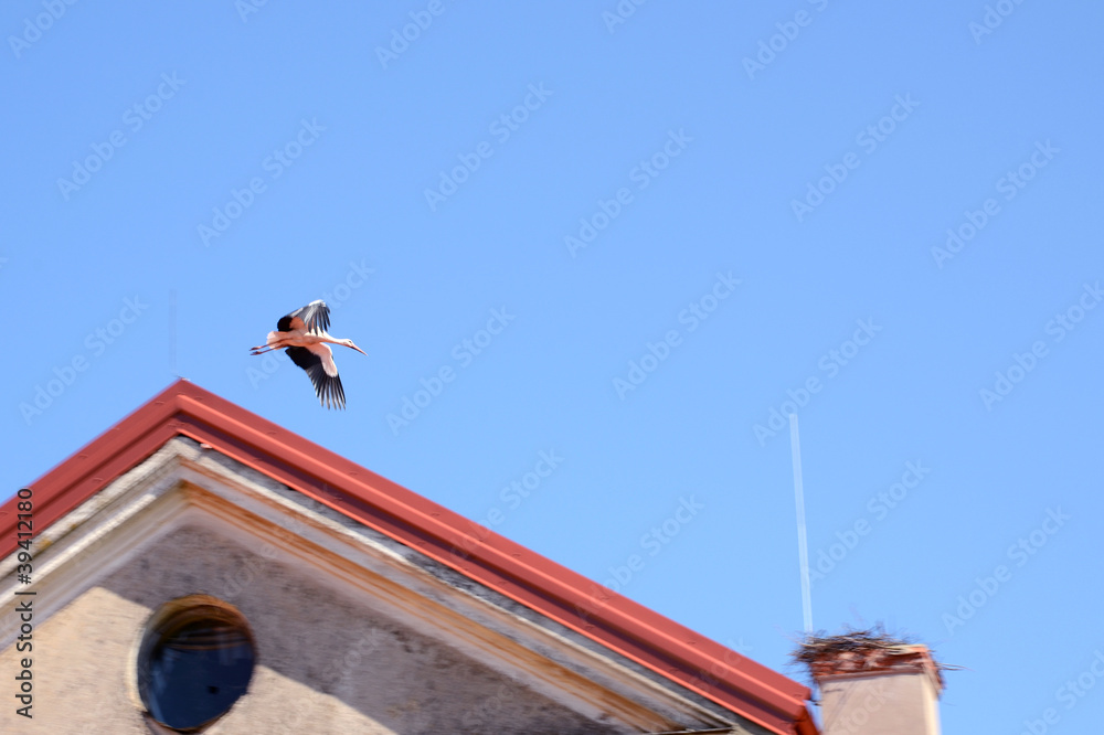 flying stork fly to nest on chimney building roof flying stork fly to nest on chimney building roof