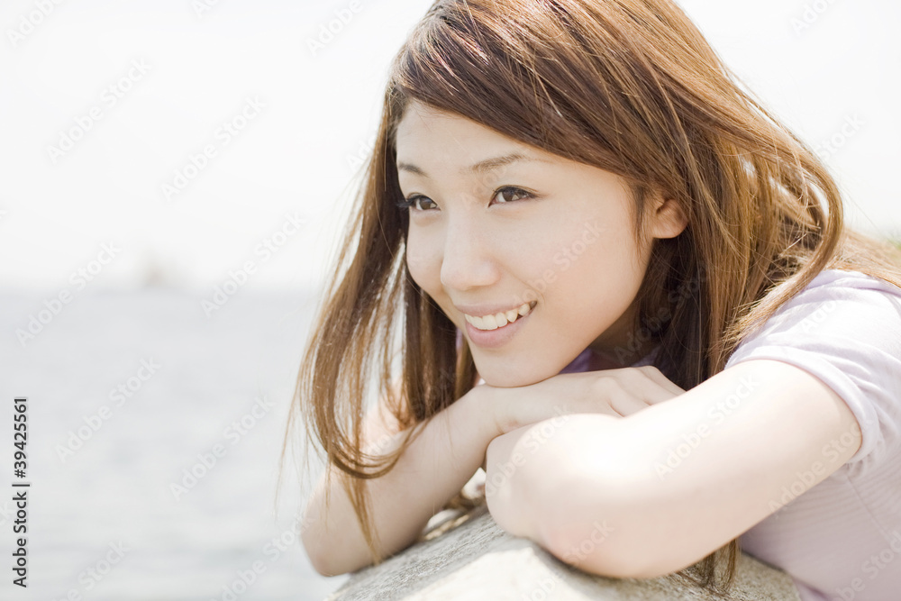 堤防で海を眺める笑顔の女性 堤防で海を眺める笑顔の女性