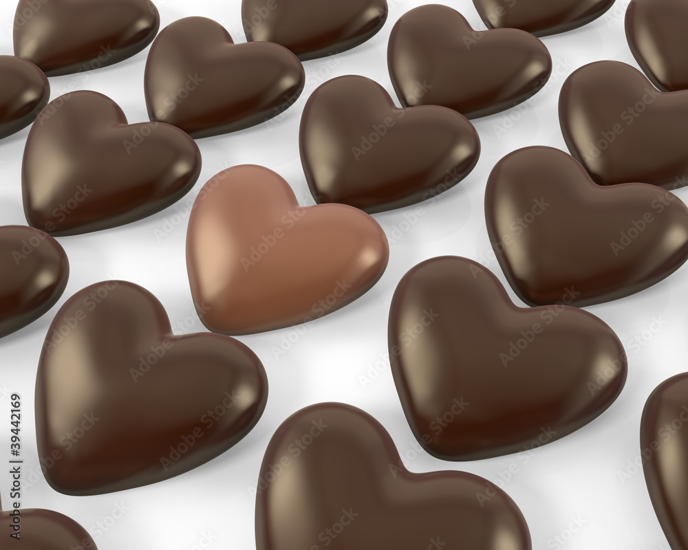 Heart shaped milk chocolate candy between dark ones Heart shaped milk chocolate candy between dark ones