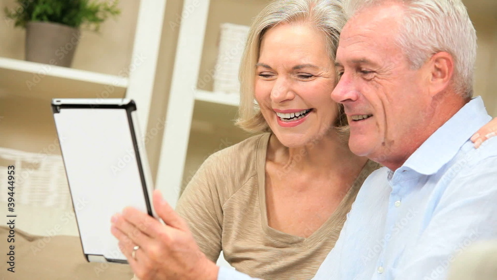 Mature Caucasian Couple Using a Wireless Tablet at Home Mature Caucasian Couple Using a Wireless Tablet at Home