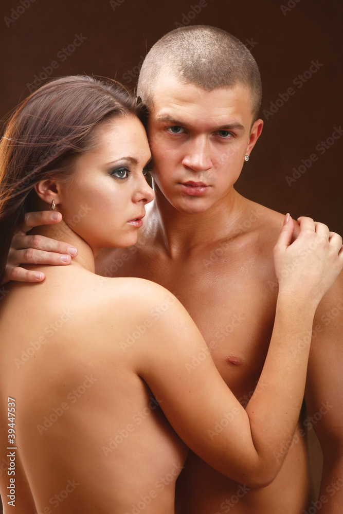 Young beautiful loving couple is embracing - on black background Young beautiful loving couple is embracing - on black background