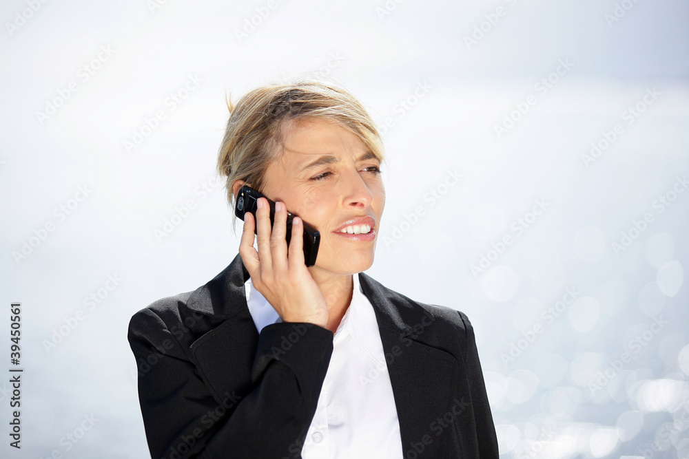Woman in suit with mobile phone outdoors Woman in suit with mobile phone outdoors
