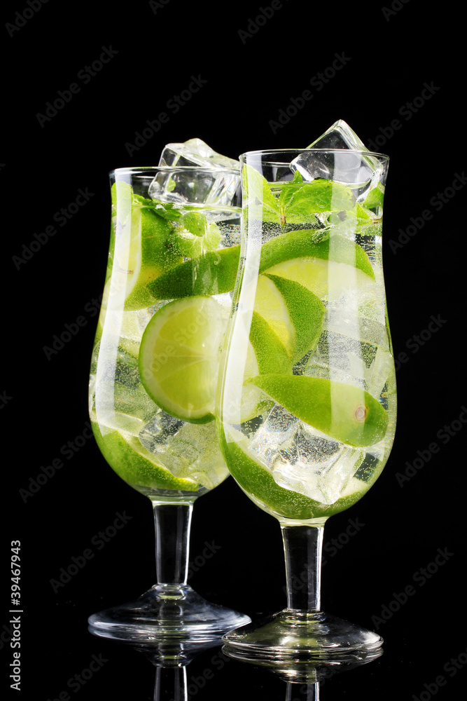 glasses of cocktails with lime and mint on black background