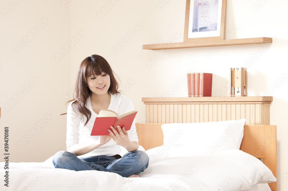 ベッドでくつろぐ若い女性 ベッドでくつろぐ若い女性