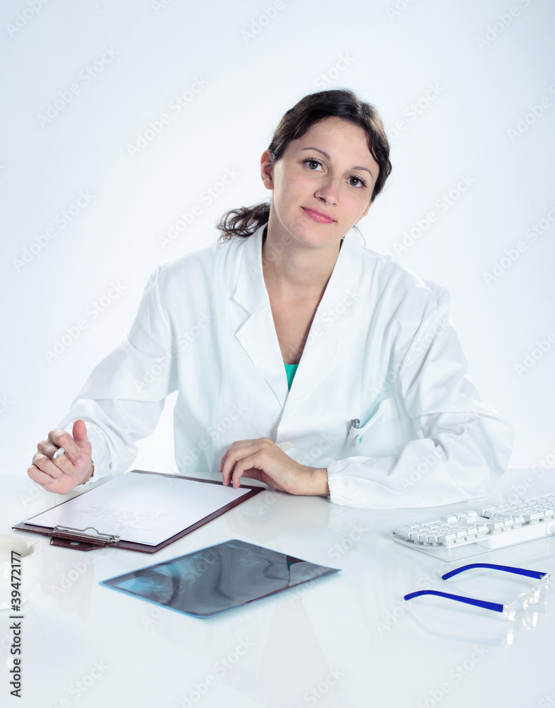 portrait of confident female doctor sitting on her desk portrait of confident female doctor sitting on her desk