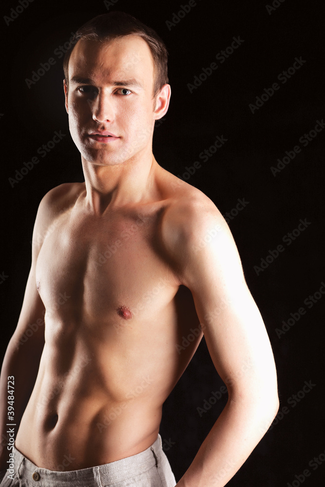 Portrait of a naked muscular man ,isolated on black background