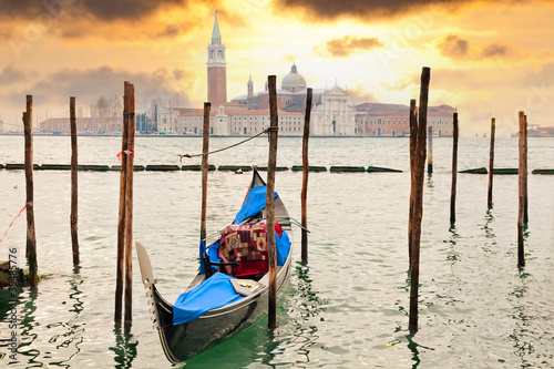 Gondola at sunset pier near in Venice, Italy