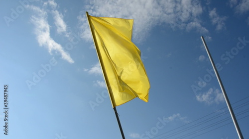yellow flag on sky background and wind