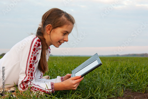 Obraz na płótnie Teen girl with electronic book laying on grass w salonie