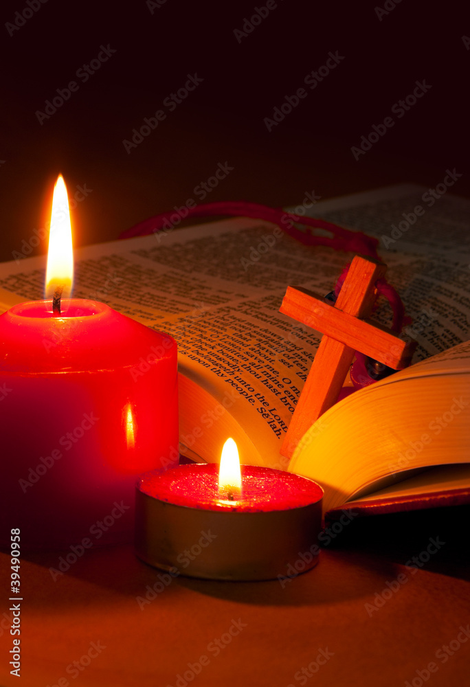 Open Bible with cross and burning candles