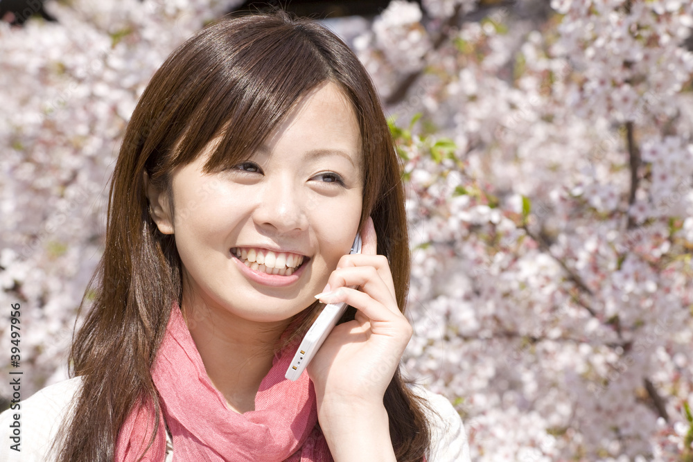 桜の下で電話をする女性 桜の下で電話をする女性