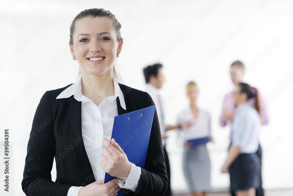 business woman standing with her staff in background business woman standing with her staff in background