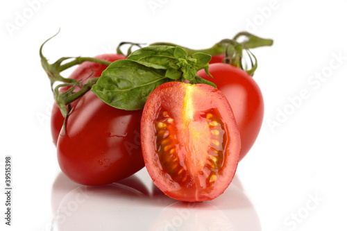 Frische Roma Tomaten mit Basilikum vor weißem Hintergrund