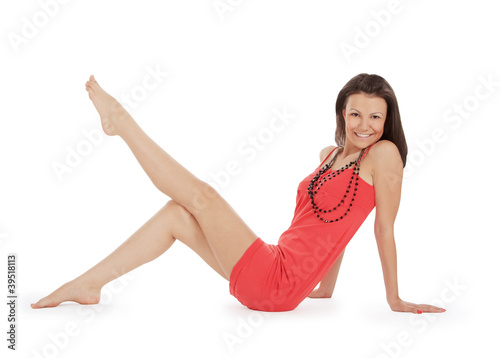 Young brunette in red dress posing over white