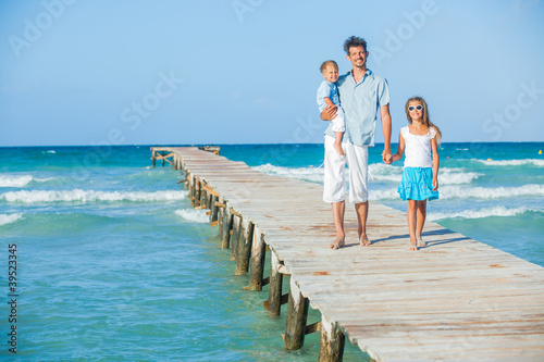 Family of three on jetty by the ocean