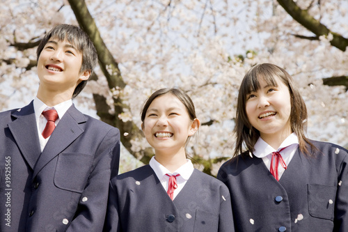 桜の下で笑っている3人の中学生