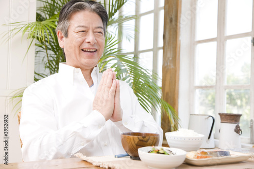 食事前に手を合わせるシニア男性