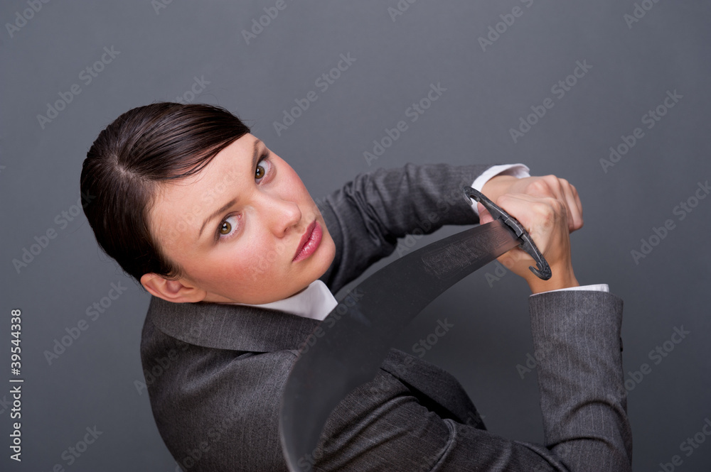 Business woman showing determination holding a sword Business woman showing determination holding a sword