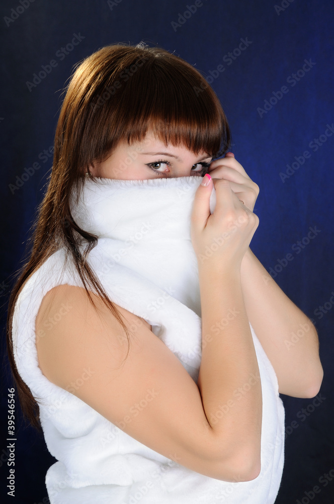 The girl hides face for artificial fur. Looking at camera The girl hides face for artificial fur. Looking at camera
