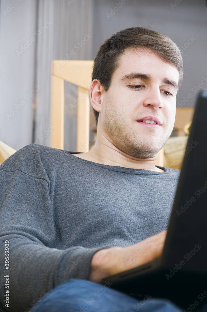 Untersicht-Oberkörperaufnahme eines jungen Mannes mit Laptop Untersicht-Oberkörperaufnahme eines jungen Mannes mit Laptop