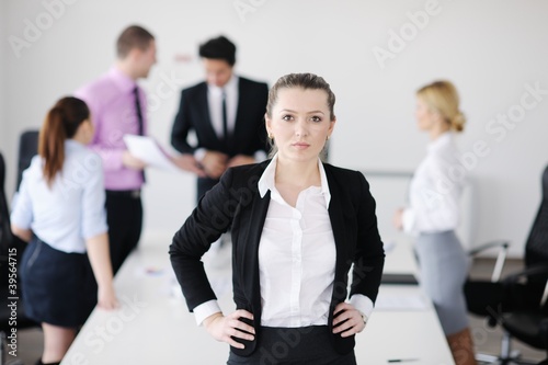business woman standing with her staff in background