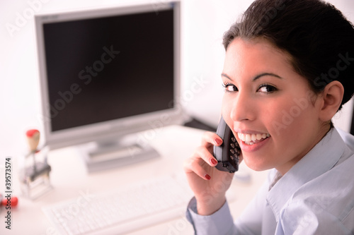 Geschäftsfrau am Schreibtisch telefoniert photo