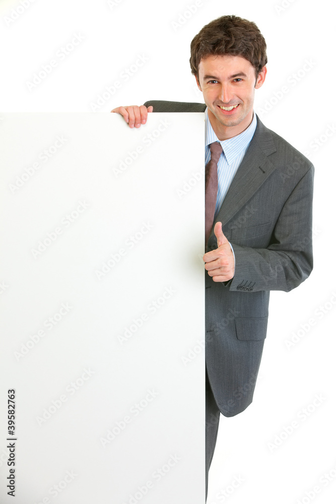 Modern businessman showing blank billboard and thumbs up gesture Modern businessman showing blank billboard and thumbs up gesture