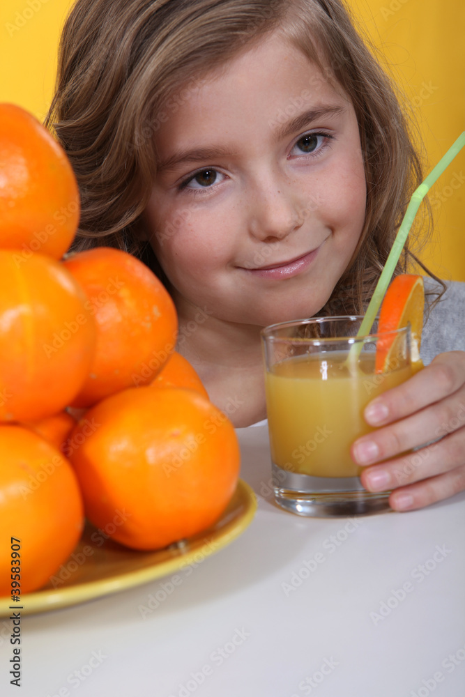 a little blonde girl drinking orange juice a little blonde girl drinking orange juice