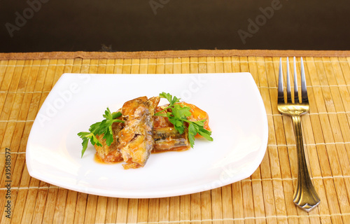 Fototapeta Naklejka Na Ścianę i Meble -  Tasty sardines on plate on wooden mat on brown background