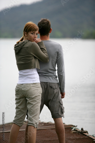 Couple stood by peaceful lake © auremar