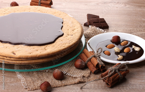 cake on glass stand and nuts on wooden table