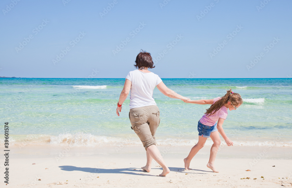 mother and daughter play together by the end of the ocean