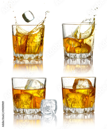 Set of scotch whiskey glasses with splash and ice isolated