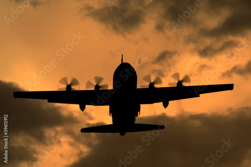Lockheed C-130 Hercules turboprop cargo aircraft at sunset
