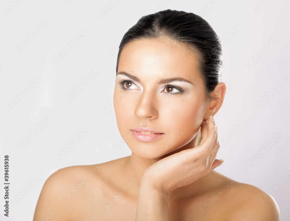 A young woman touching her face , isolated on white background A young woman touching her face , isolated on white background