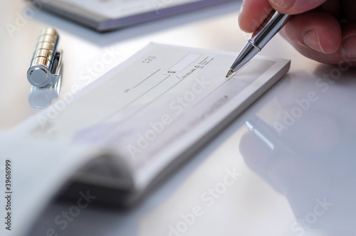 Close-up businessman hand hold pen fill a banque cheque document
