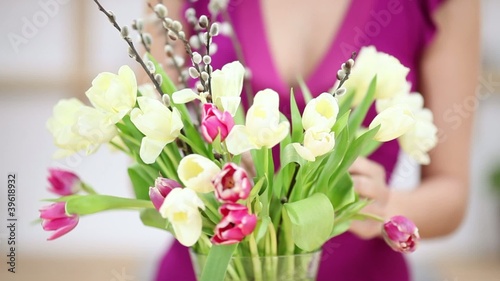 frau stellt einen strauß tulpen in eine vase