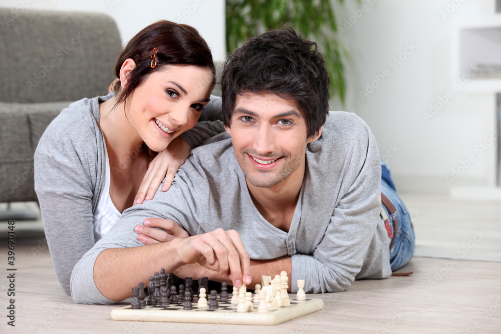 Couple laying on floor playing chess Couple laying on floor playing chess
