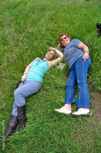 mother and daughter laying on grass