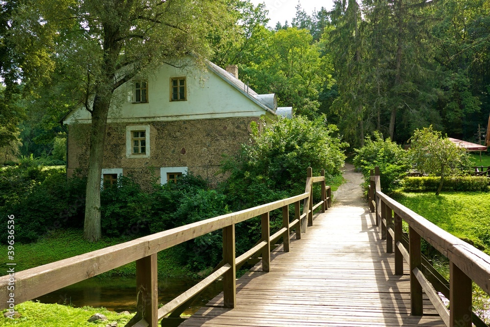 Wooden bridge and an old stone house.