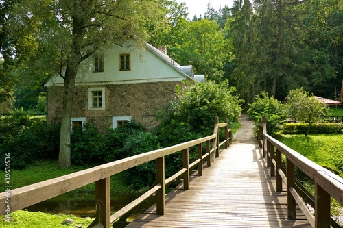 Wooden bridge and an old stone house.