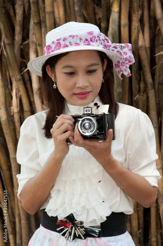 Pretty Asian woman use vintage camera .