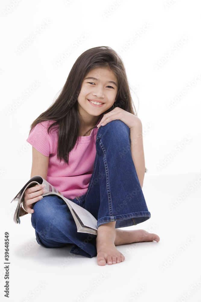 Little girl sitting on floor reading a magazine Little girl sitting on floor reading a magazine