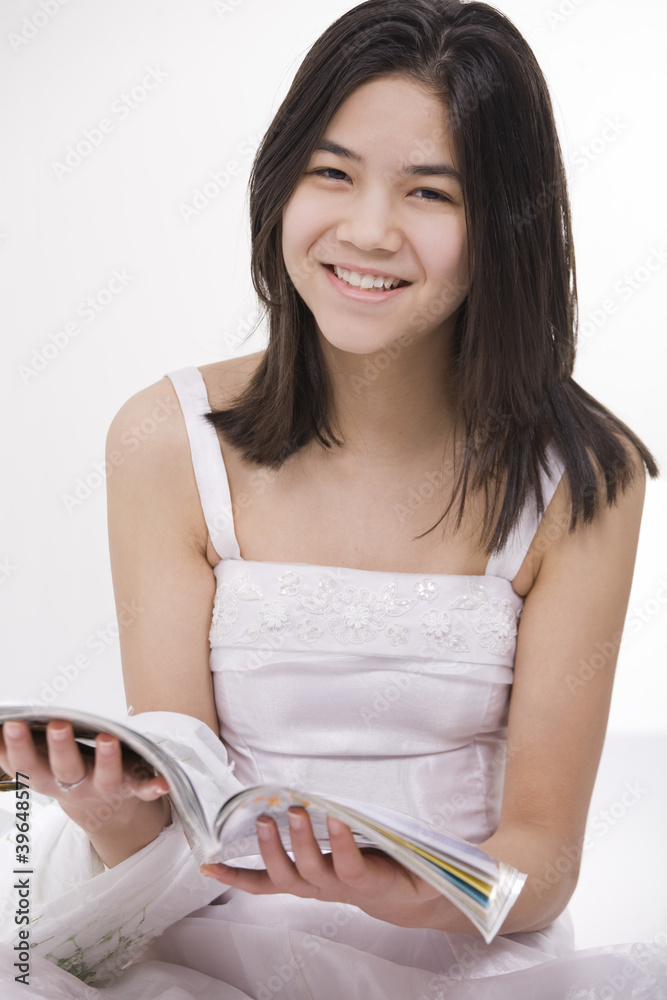 Beautiful young teen girl in white dress sitting, reading Beautiful young teen girl in white dress sitting, reading