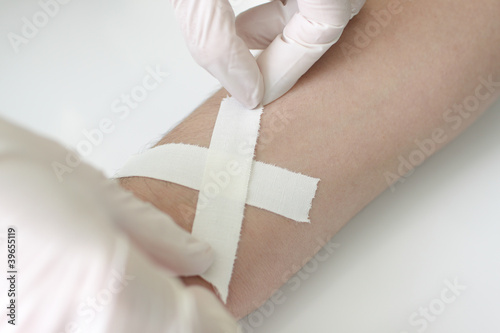 Photography superimposition of cohesive bandage on a wound to his wrist,