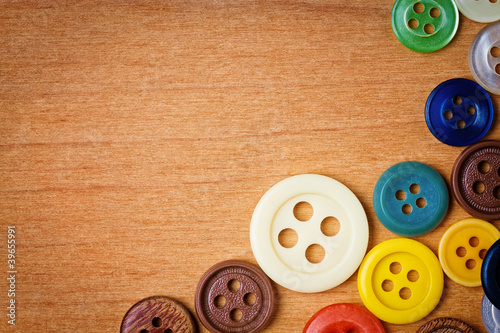 Colorful sewing buttons on a wooden background