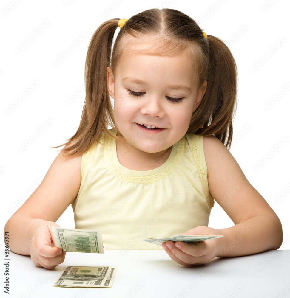 Cute cheerful little girl is counting dollars Cute cheerful little girl is counting dollars