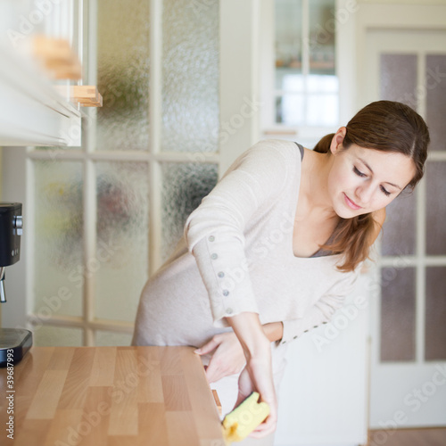 Billede på lærred Young woman doing housework, cleaning the kitchen