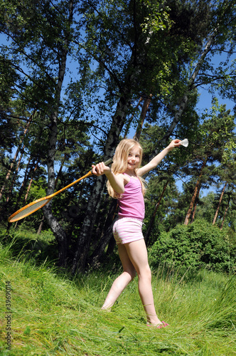 Little girl playing badminton in the park
