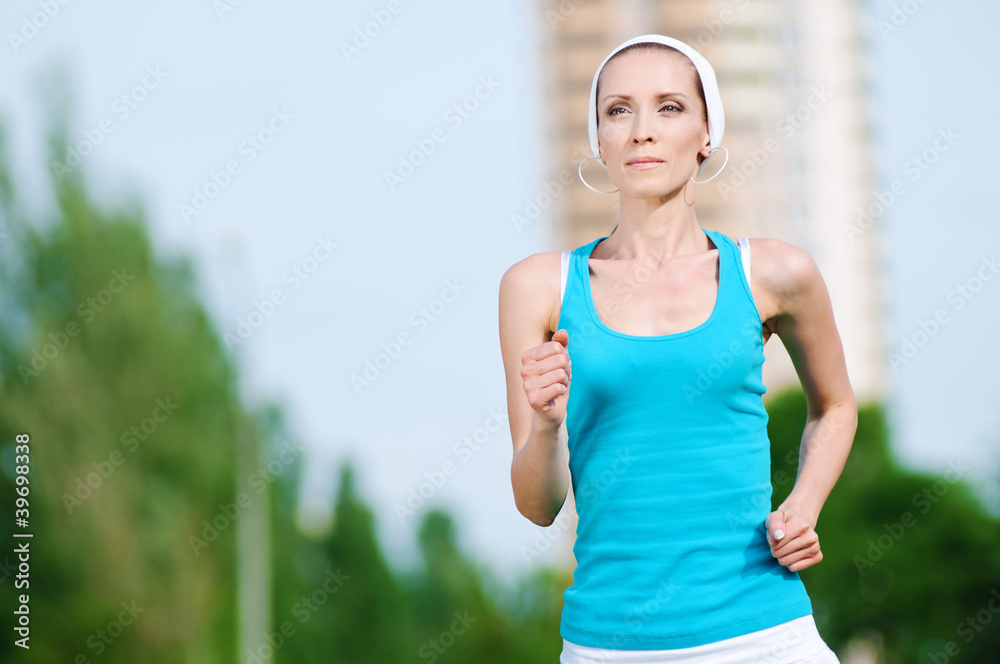 Fototapeta premium Beautiful woman running in green park